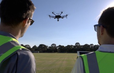 A pair of remote pilots flying a drone